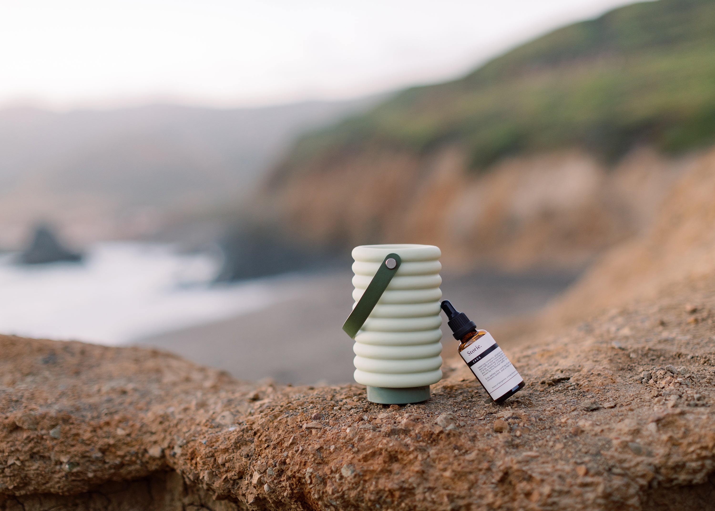 Waterless diffuser and essential oil on rocky beach